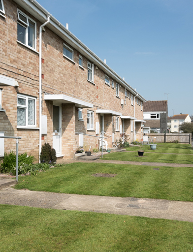 Lawns and gardens to the front of resident's homes with pathways leading to the front doors 