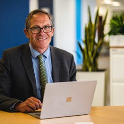 Chief Executive Bruce Moore works from his laptop at a table in the office