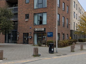 Exterior of Bellerophon House, a tall apartment block with a sign for Chesters Hair Salon on the bottom floor.