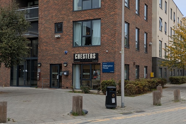 Exterior of Bellerophon House, a tall apartment block with a sign for Chesters Hair Salon on the bottom floor.