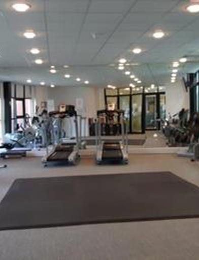 Inside the communal gym with cardio equipment and large fitness mat in the centre