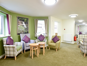 Communal area with soft seating and armchairs at Acre Court