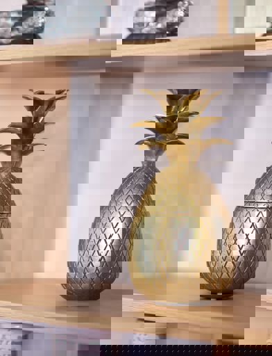 Gold pineapple ornament on a shelf 
