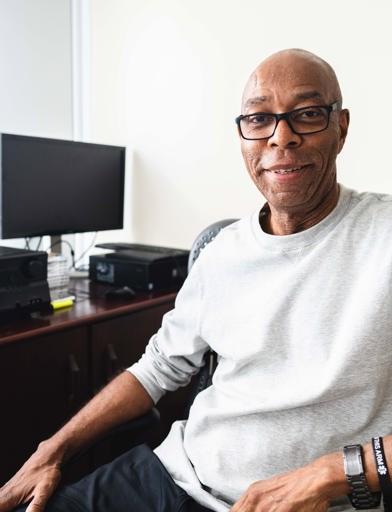 Resident smiling in front of a computer  