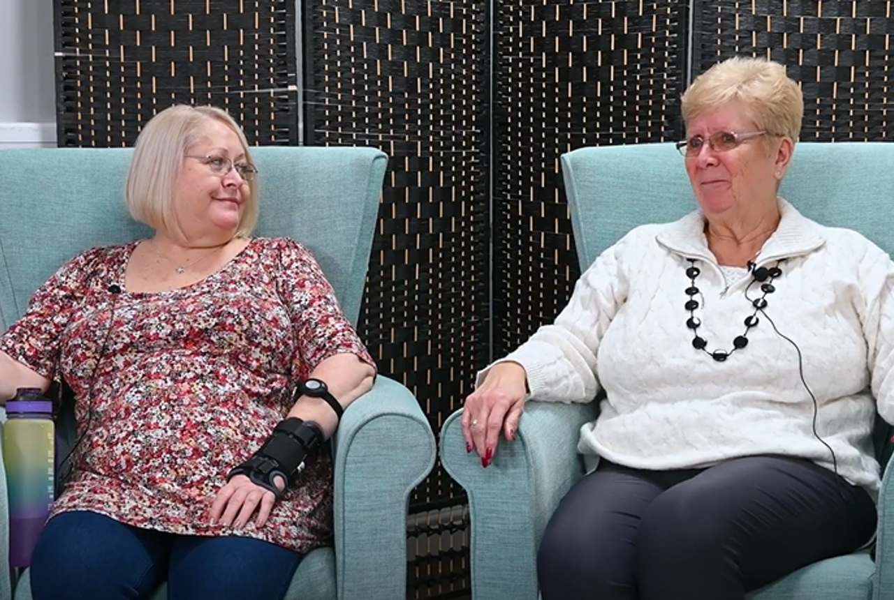 Two residents sitting on arm chairs