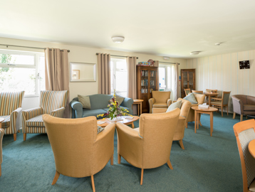 Residents' lounge with soft seating and coffee tables