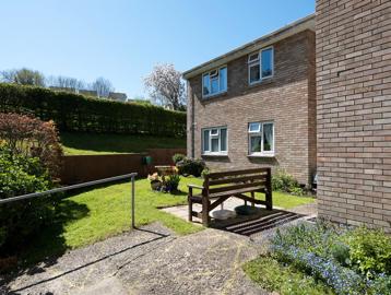 Communal garden to the rear of the scheme on a bright, sunny day