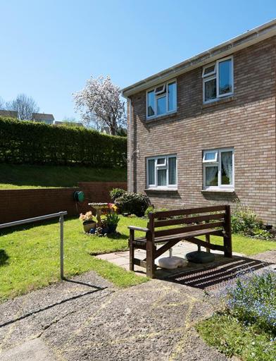 Communal garden to the rear of the scheme on a bright, sunny day 