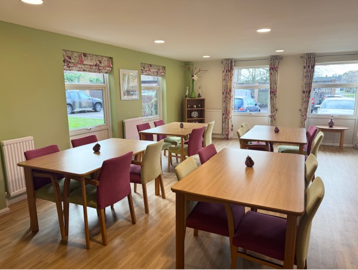 Dining area with four tables and chairs in a brightly coloured room