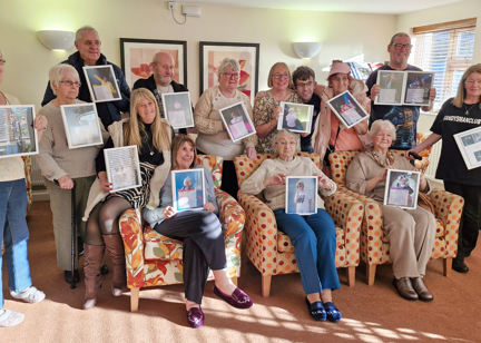 Residents hold photos of themselves, dressed up as iconic music stars