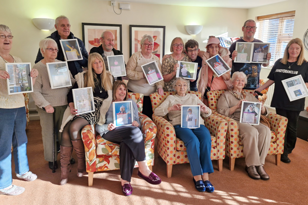 Residents hold photos of themselves, dressed up as iconic music stars