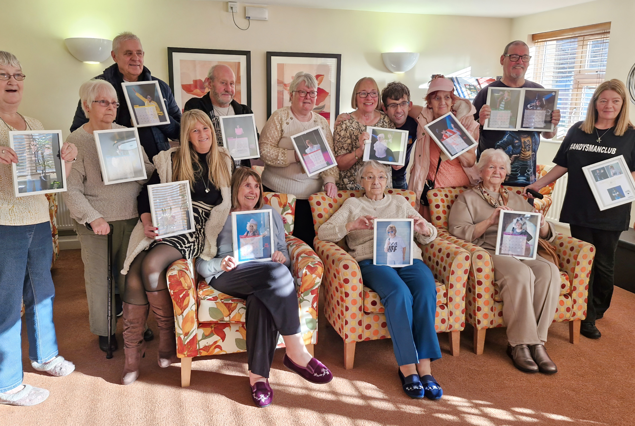 Residents hold photos of themselves, dressed up as iconic music stars