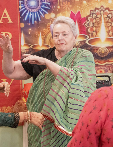Resident dressed in Sari, learning traditional dance poses 