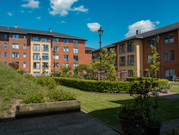 Central garden area with views of a veranda surrounded by a circular hedgerow and planters