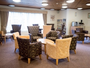 Communal lounge with soft seating armchairs and coffee tables
