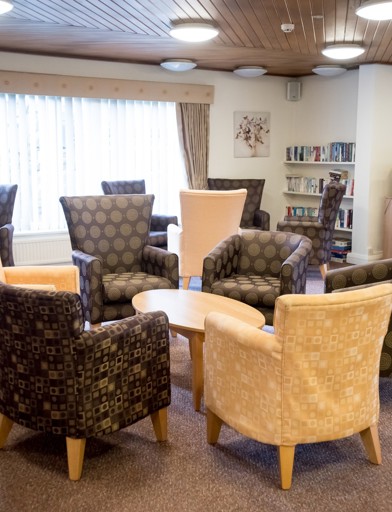 Communal lounge with soft seating armchairs and coffee tables