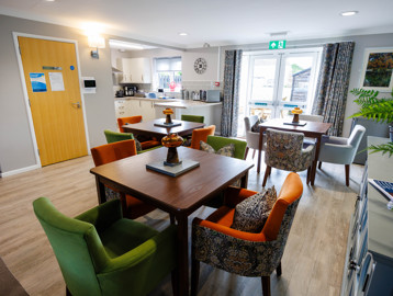 A modern and refurbished dining area with tables and chairs in a kitchen