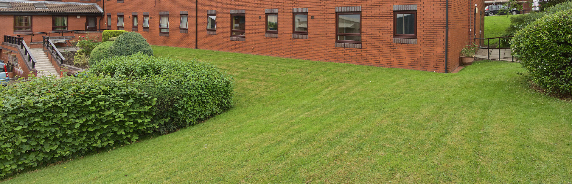 Rear garden with large grass area and steps leading up to the scheme