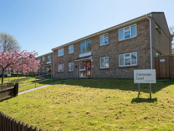 A path with handrail leading up to the main front door of the scheme with grassed areas either side