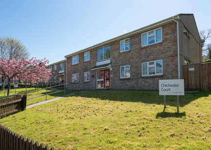 A path with handrail leading up to the main front door of the scheme with grassed areas either side