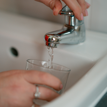 a tap with running water into a glass