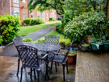 Garden area with four pretty chairs and a table made of iron