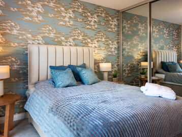 Inside the master bedroom of the show apartment at Glen Mill House with a double bed and furnishings