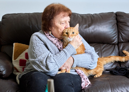 A resident cuddles her cat on the sofa