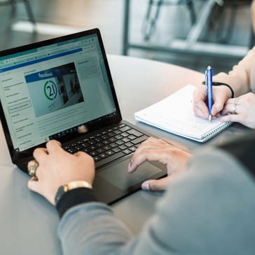 A Housing 21 employee works on a laptop which is displaying policy information 
