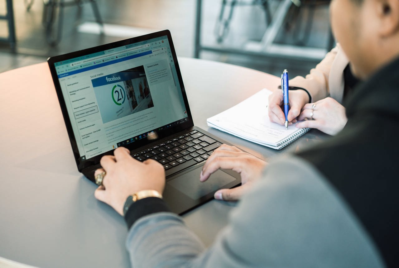 A Housing 21 employee works on a laptop which is displaying policy information 