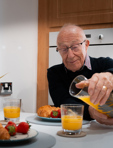 A resident enjoying breakfast with his friend in their apartment 