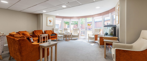 A selection of armchairs in front of a bright, full length bay window