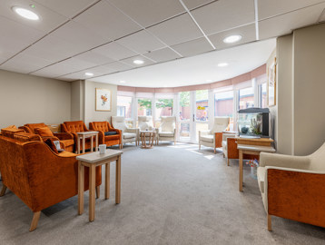 A selection of armchairs in front of a bright, full length bay window