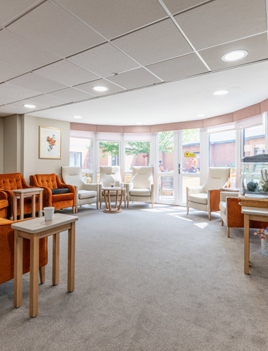 A selection of armchairs in front of a bright, full length bay window