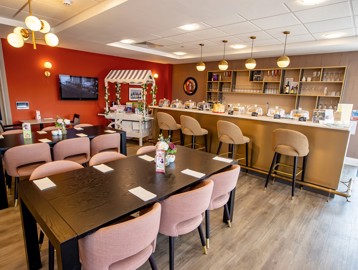A photo of the cafe/bistro area at Poppy Gardens with tables and chairs and a bar area