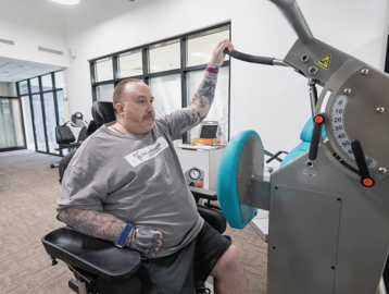 Chris, a Housing 21 resident, uses gym equipment as part of his physiotherapy 