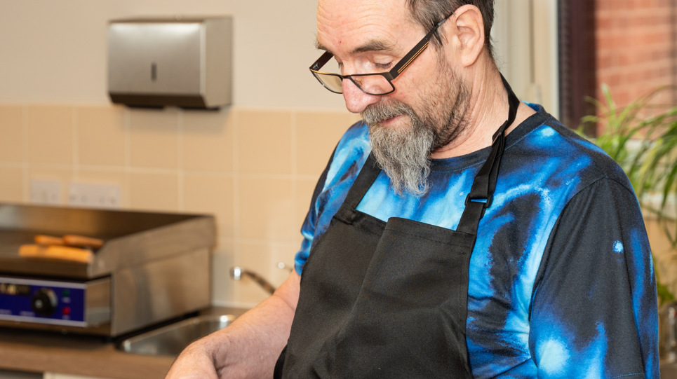 Resident with a mixing bowl in a kitchen