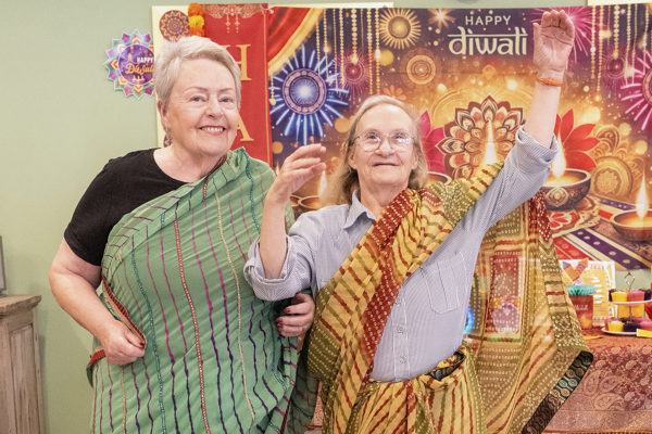 Two residents dance and pose in Sari dresses