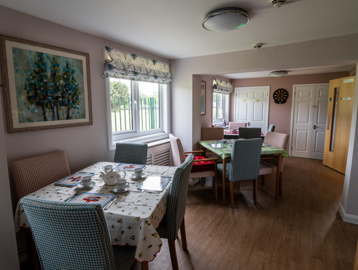 Dining room tables and chairs set up for afternoon tea