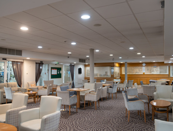 The cafe/bistro with ample seating, tables and a bar with dart board