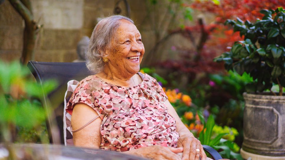 Resident smiling sitting in a garden