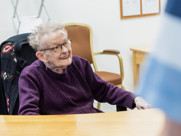 Resident sitting at a desk smiling