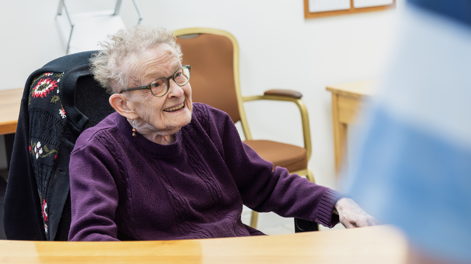 Resident sitting at a desk smiling