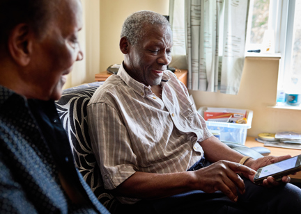 Resident smiling typing on a mobile phone