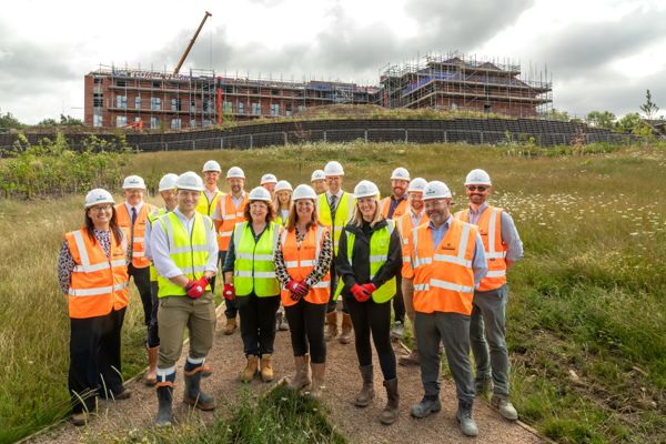 Housing 21 colleagues and partners in a group standing in front of a new extra care scheme 