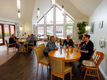 Residents sitting and socialising in the cafe area at Mere View