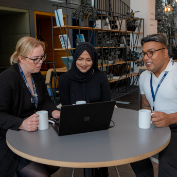 Corporate employees sitting down with laptops 