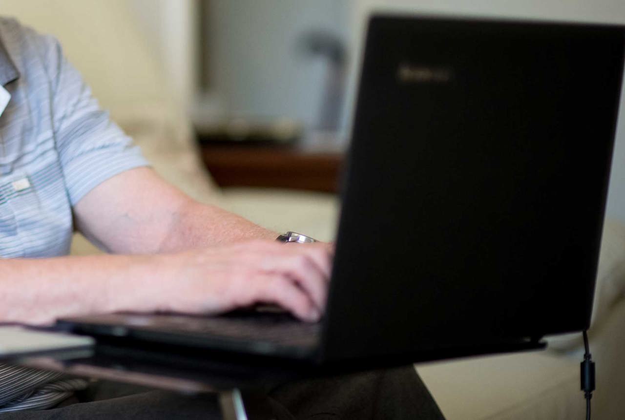 A Housing 21 resident types on a laptop