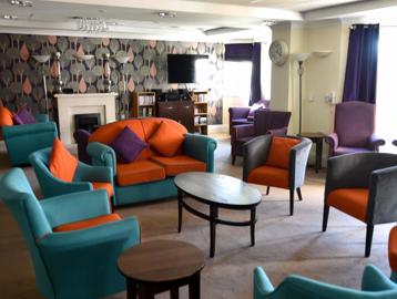 Resident's lounge area with sofa's, armchairs and tables