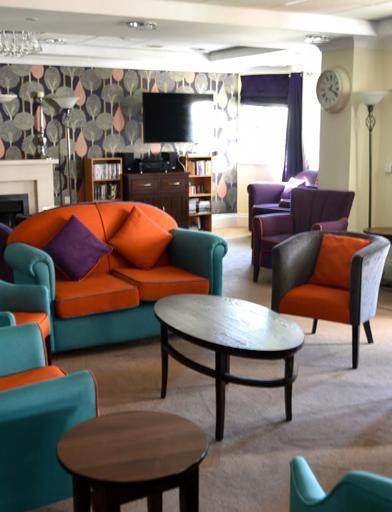 Resident's lounge area with sofa's, armchairs and tables 